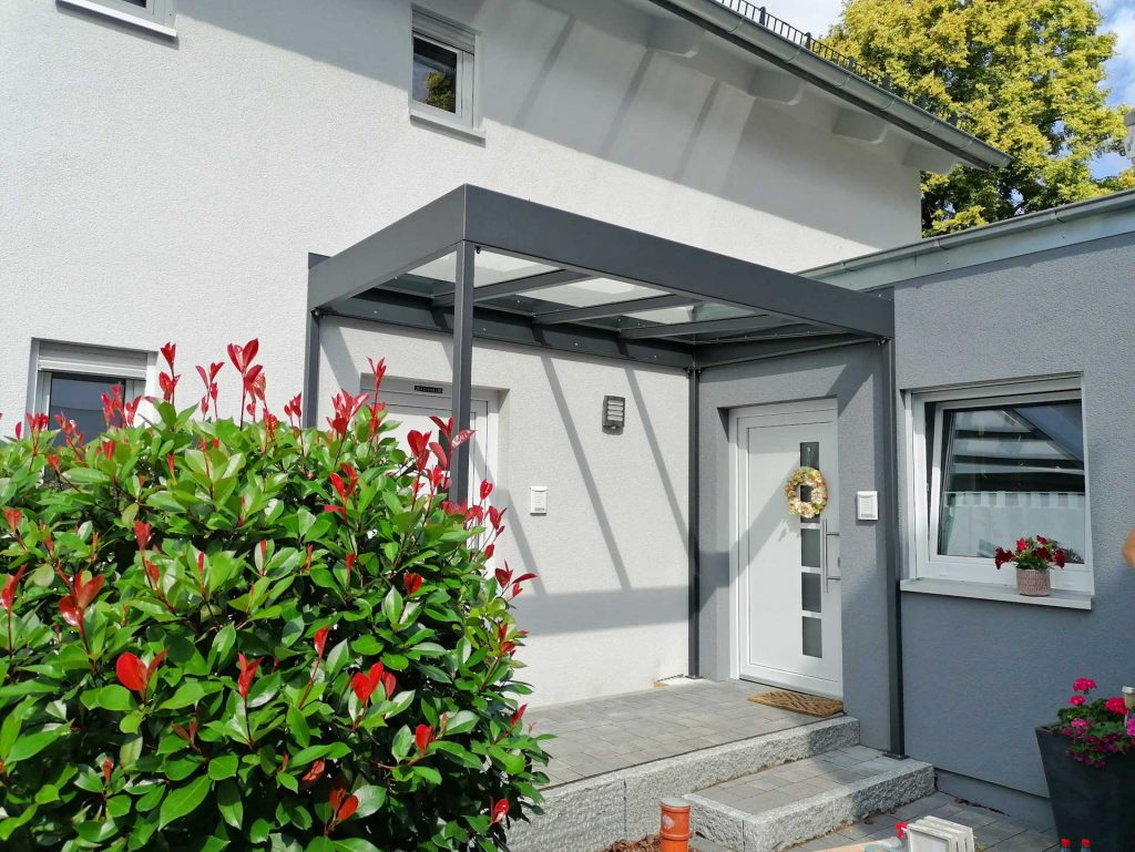 Schönes Vordach an einem beigen Haus mit Seiteneingang