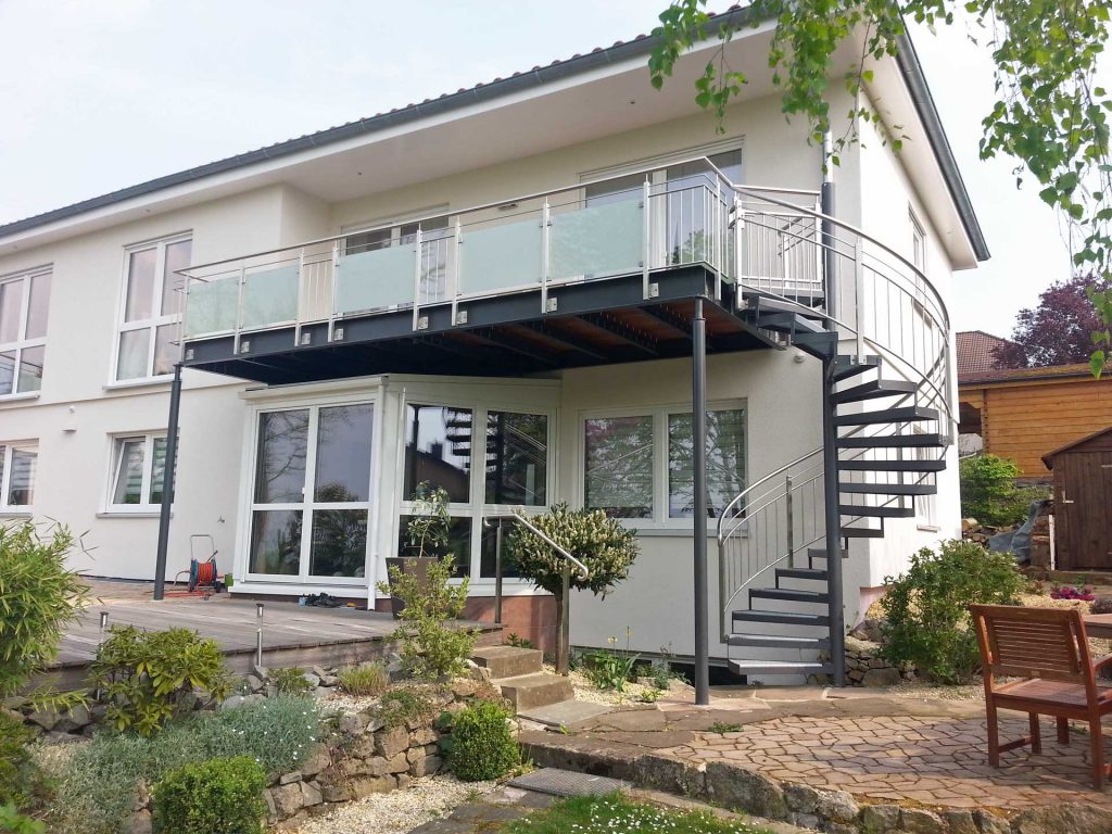 Stahlbalkon mit Spindeltreppe auf Stützen, Konstruktion und Treppe farbig Pulverbeschichtet, Treppengeländer als Edelstahlgeländer mit vertikalen Füllstäben, Balkongeländer aus Edelstahlpfosten mit Milchglasfüllung