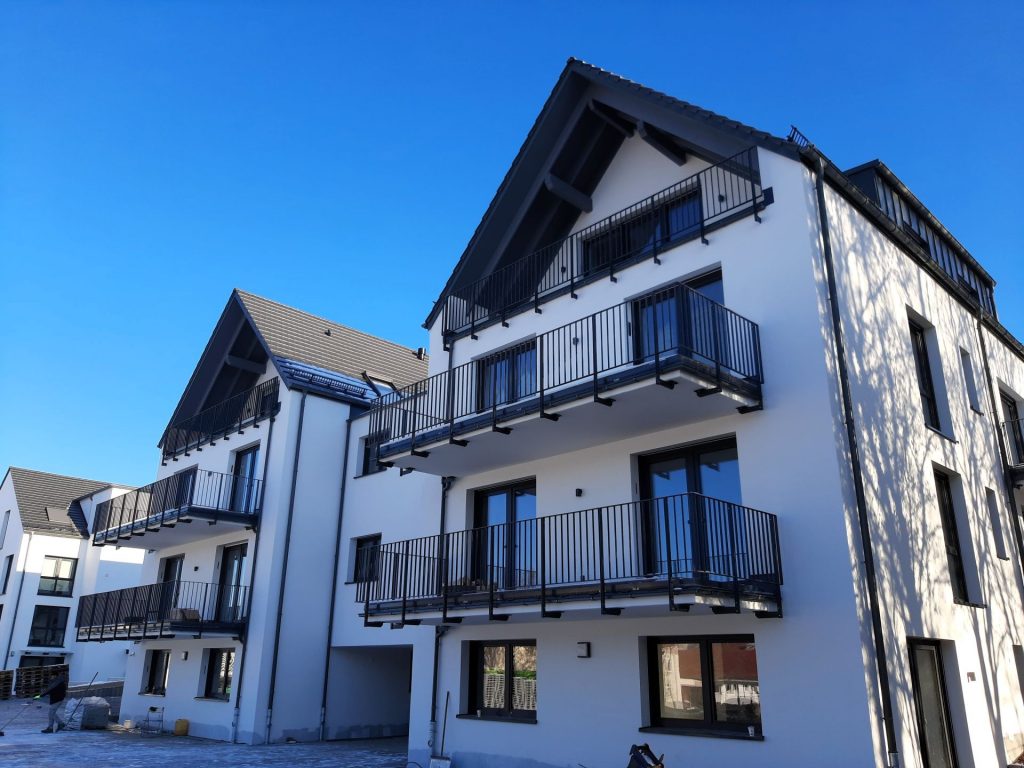 Stabgeländer mit aus Flachstählen mit befestigung von unten an den Betonbalkon. Alle stahlteile sind feuerverzinkt und farbig pulverbeschichtet.