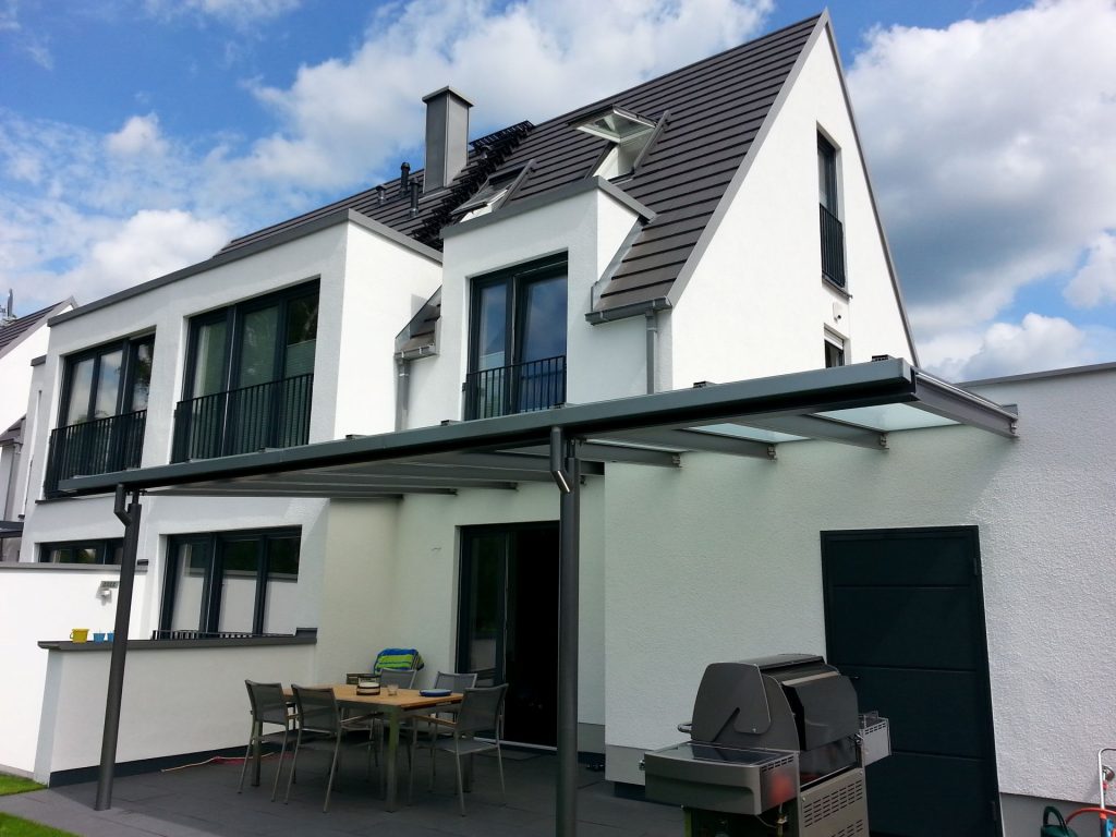 Vordach aus in der Wand verankerten Stahlsparren. Vorne auf einem Unterzug auf 3 Stützen aus Rundrohr. Mit Milchglasplatten belegt. gesammte stahlkonstruktion feuerverzinkt und anthrazit Pulverbeschichtet.