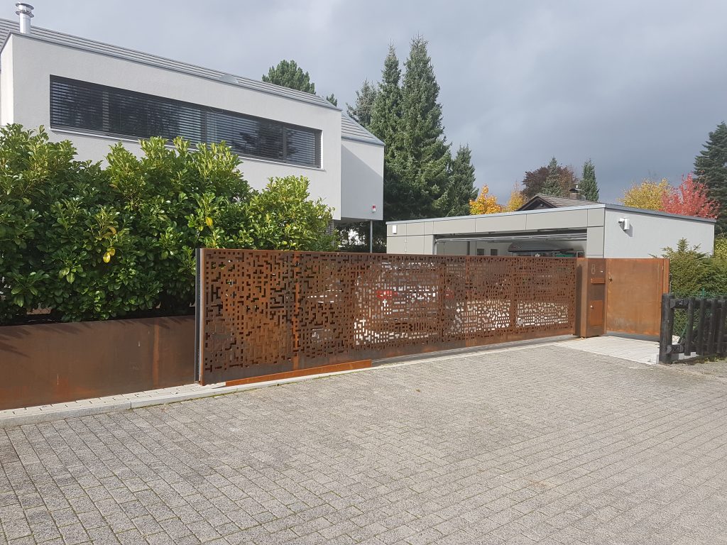 automatisierte Schiebetoranlage mit Cortenstahlblechen verkleidet mit kundenspezifischen Ausschnitten